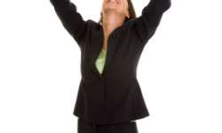 Businesswoman with fists in air looking up